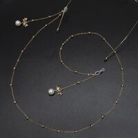 Gold-colored metal non-slip chain, with pendant bow with pearl and beads, for glasses and masks GL573